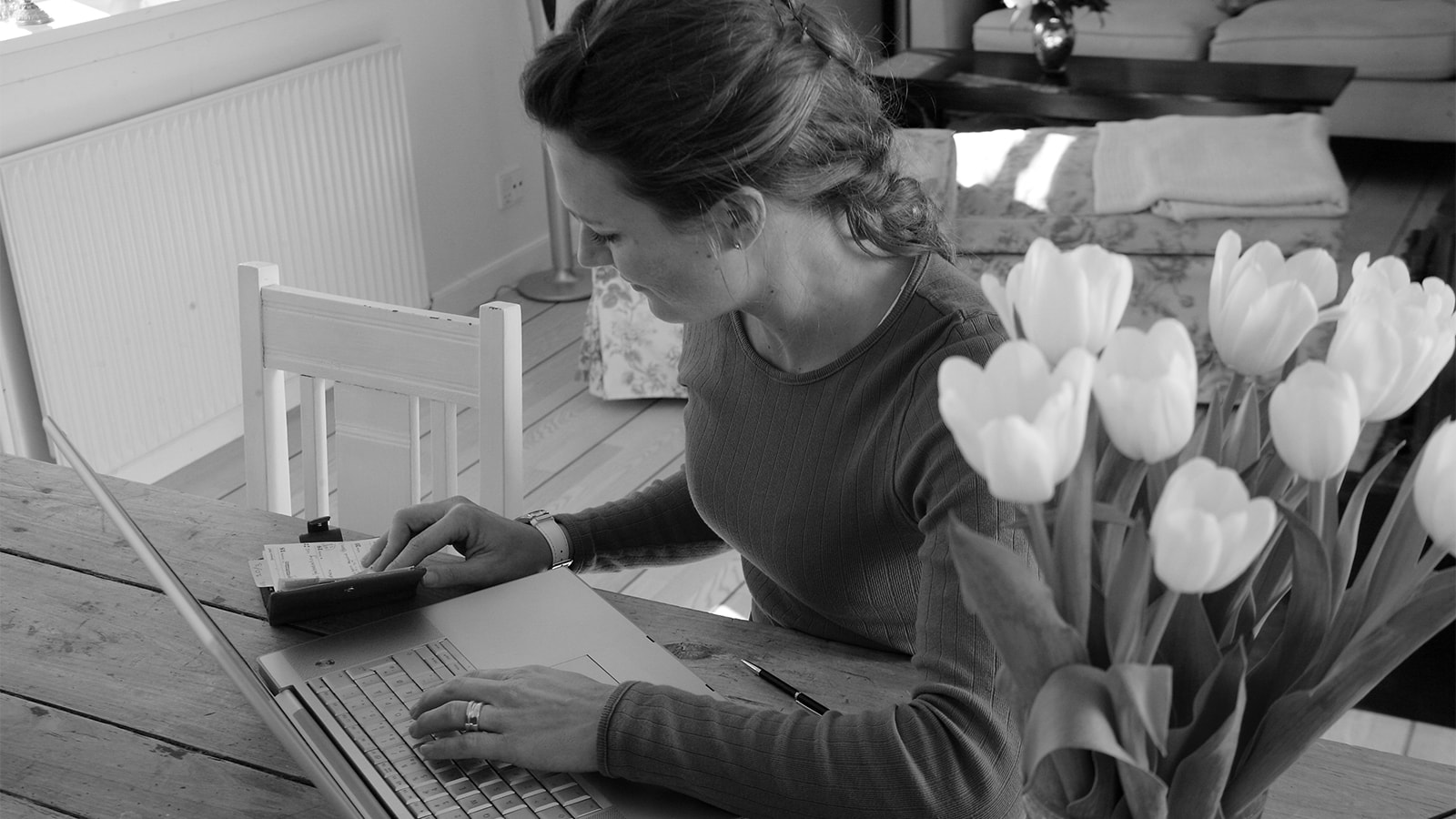 En rødhåret kvinde arbejder ved sin computer